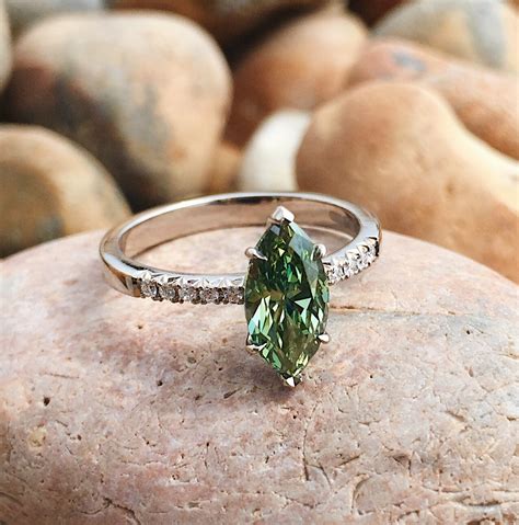 Woman finds lost engagement ring diamond that fell under nyc newsstand. 18ct white gold and treated green marquise diamond ...