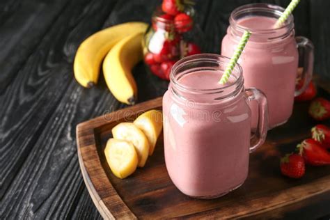 Mason Jars With Tasty Strawberry Smoothie And Banana On Dark Table Stock Image Image Of Liquid