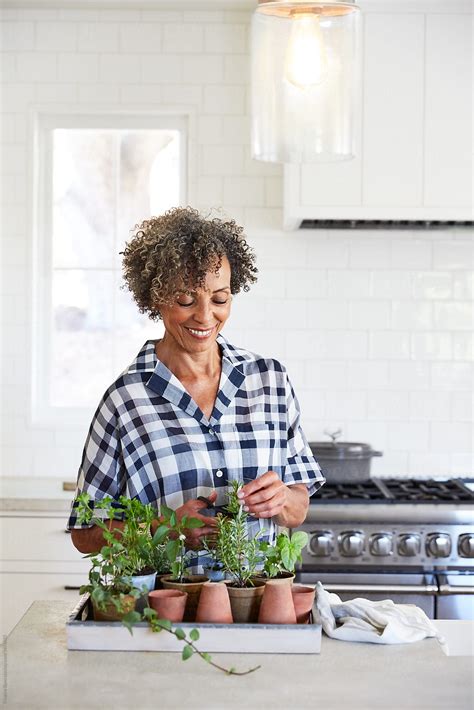 Senior African American Woman With Fresh Herbs In Her Kitchen By