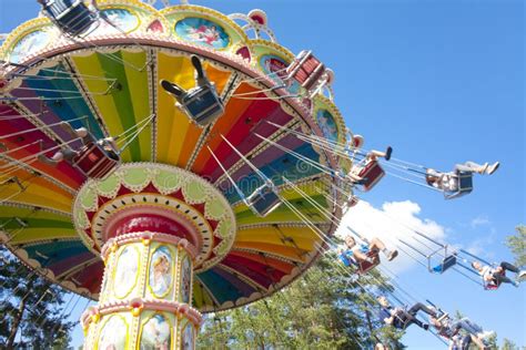 Colorful Chain Swing Carousel In Motion At Amusement Park On Blue Sky
