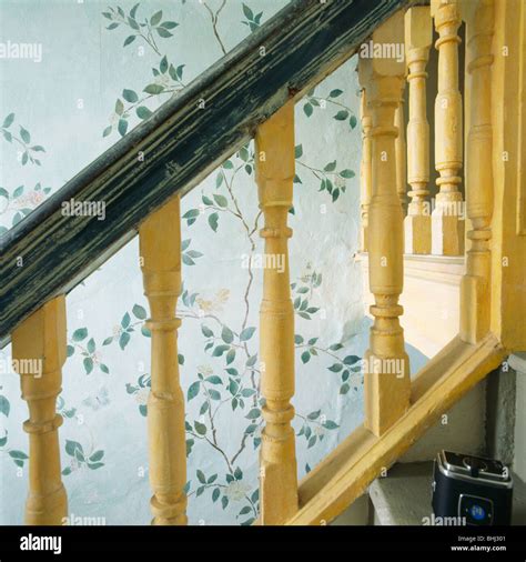 Close Up Of Yellow Painted Banisters On Staircase With Stenciled Wall