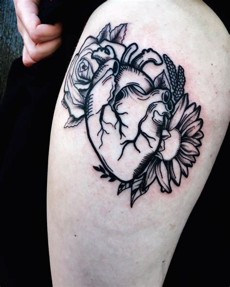 Black And Grey Anatomical Heart And Floral Thigh Tattoo By