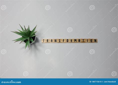 The Word Transformation Written In Wooden Letter Tiles On A White