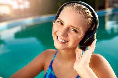premium photo relaxed smiling woman listening to music in headphones bathing in swimming pool