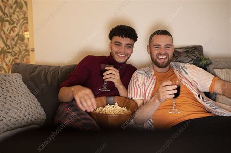 happy gay couple with wine and popcorn watching movie stock image f034 1196 science photo