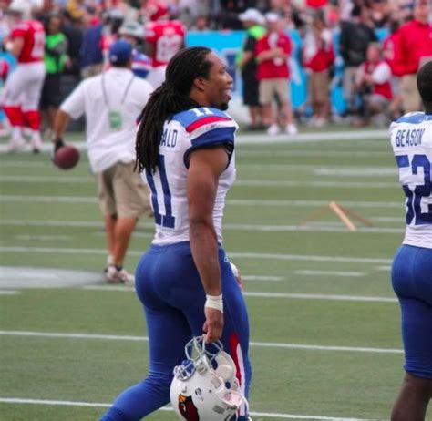 Two Football Players Are Standing On The Field With Helmets In Their