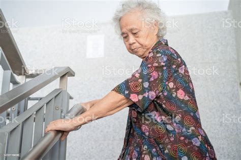 asian senior or elderly old lady woman patient use handle at stairs security support in building