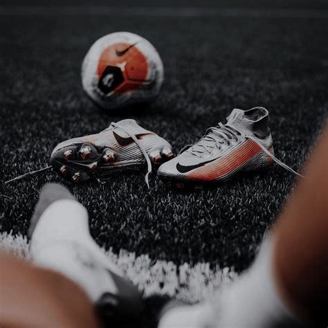 Two Soccer Shoes And A Ball On The Ground