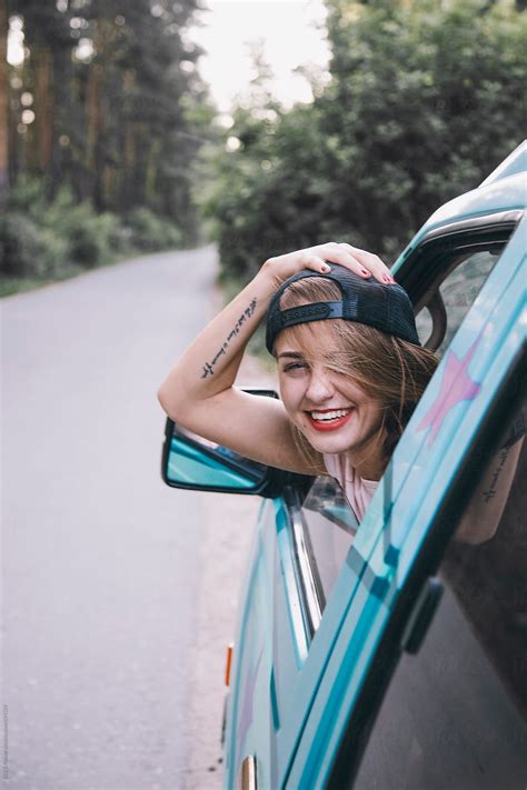 girl smiling from a car window by danil nevsky stocksy united smile girl window photography