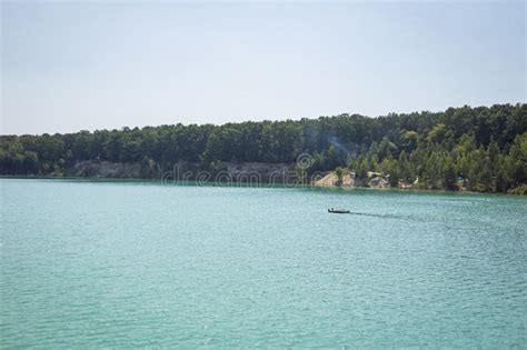 Lake In A Forest With Clear Turquoise Water Against A Background Stock