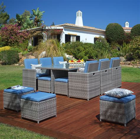 An Outdoor Dining Set With Blue Cushions On A Wooden Deck