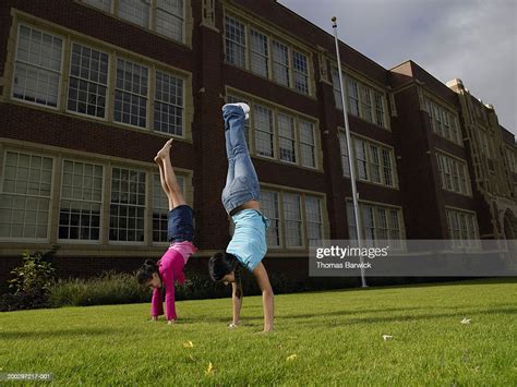 Two Girls Doing Handstands In Front Of School Photo Getty Images