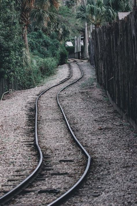 Vertical Shot Of The Winding Uneven Railway Tracks Alongside The Green