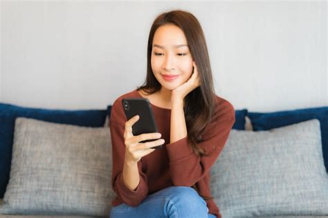 Retrato Hermosa Joven Asiática Usar Teléfono Móvil Inteligente En El Sofá En La Sala De Estar