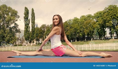 woman flexible body practice split on fitness mat outdoors nature background girl stretching