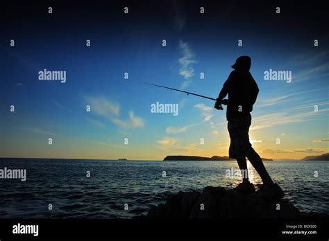 Man Fishing On Sunset Stock Photo Alamy