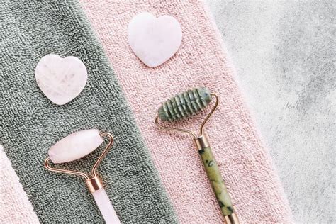 face massage tools gua sha massages and jade facial rollers on a pink towel stock image image