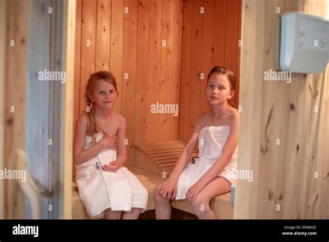 Dos Niñas Han Envuelto En Toallas Y Están Sentados En Una Sauna