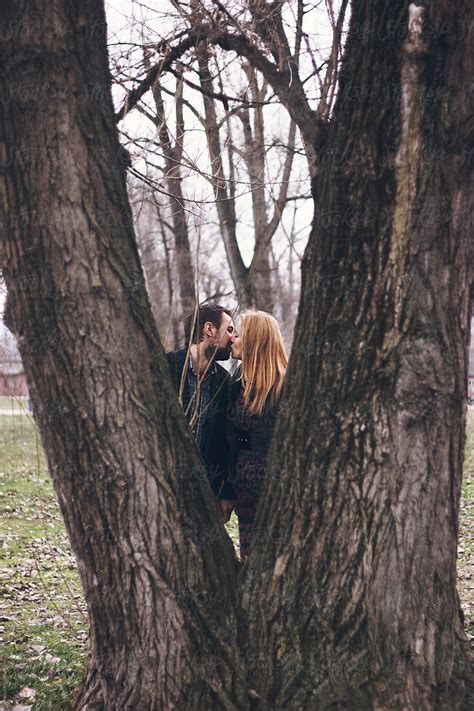 Couple Kissing Each Other Behind The Double Tree Del Colaborador De