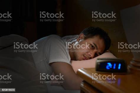 Depressed Man Suffering From Insomnia Lying In Bed Stock Photo