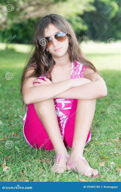 Teenage Girl Sitting In The Grass Wearing Sunglassses Stock Image