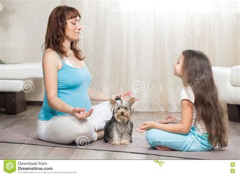 Madre Embarazada Que Medita En Casa Con Su Hija Y Perro Casero Imagen