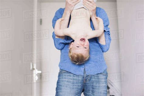 Father Holding Baby Upside Down Stock Photo Dissolve