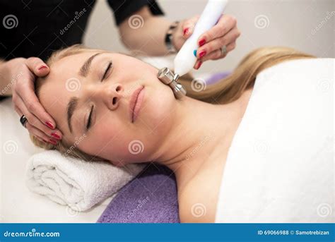 Young Woman Lying On Massage Table Receiving Face Massage Beaut Stock