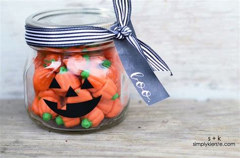A Jar Filled With Carrots And Jack O Lantern Candies On Top Of A