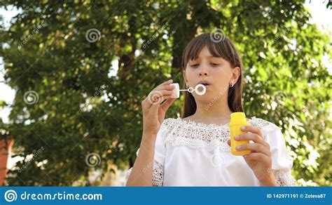 Happy Girl Blowing Beautiful Soap Bubbles In The Park In Spring Summer And Smiling Slow Motion