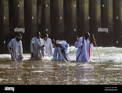 Members Of The Shembe Church Pray While Kneeling In Water On The Durban