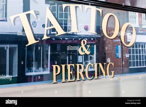 Tattoo And Piercing Sign In Shop Window Stock Photo Alamy