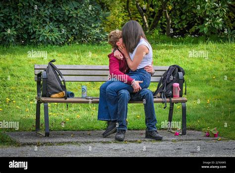 Young Couple Kissing On Park Bench Stock Photo Alamy