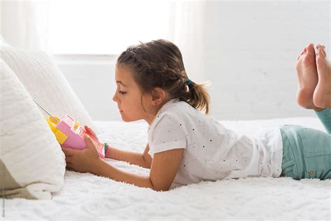 A Girl Laying On A Bed Listening To The Radio By Stocksy Contributor