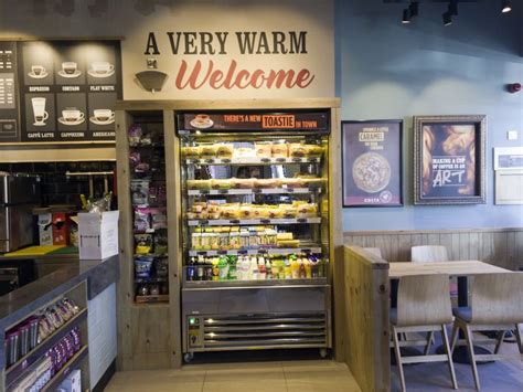 A Very Warm Welcome Sign In The Front Of A Deli With Lots Of Food