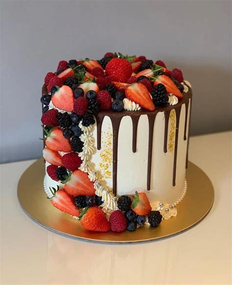 gorgeous assembly of fresh summer fruits with a delicate tower around the sides of the buttercre
