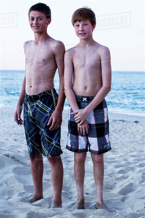 Portrait Of Two Babes Standing On Beach Stock Photo Dissolve