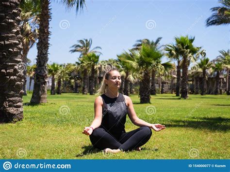 Girl Doing Yoga On The Grass Among Palm Trees Stock Image Image Of