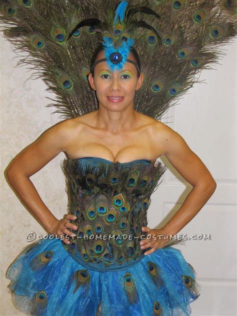 A Woman Wearing A Blue And Green Costume With Peacock Feathers On It S Head