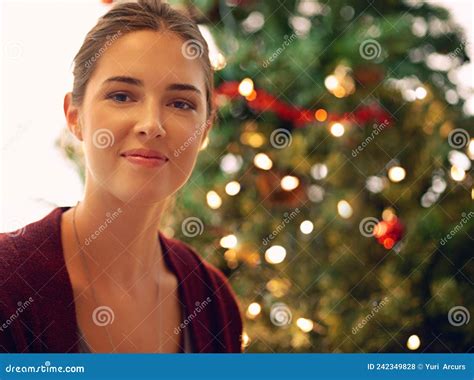 Sending Seasons Greetings Portrait Of A Beautiful Young Woman In Front Of A Christmas Tree