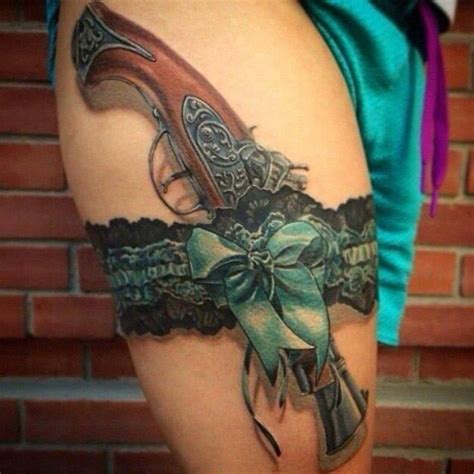 Pistol And Lace Garter Tattoo On Thigh