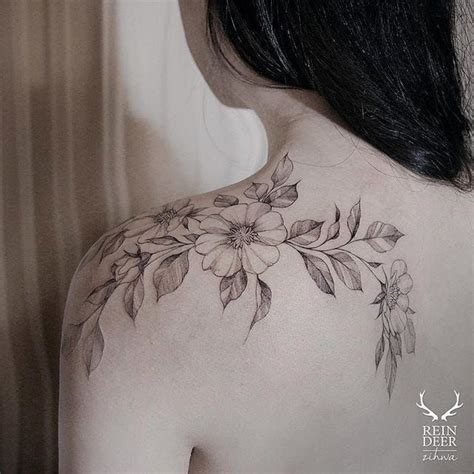 The Back Of A Womans Shoulder With Flowers And Leaves On Her Left Side