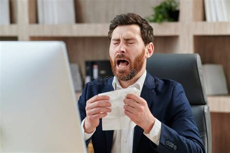Business Workers At His Office Desk Sneezes And Feels Bad Sickness