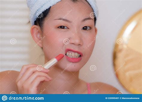 Young Beautiful And Happy Asian Chinese Woman With Towel Head Wrap Applying Makeup Doing Funny