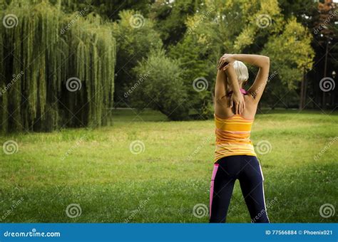 Back View Young Woman Stretching Before Exercise In Park Stock Photo