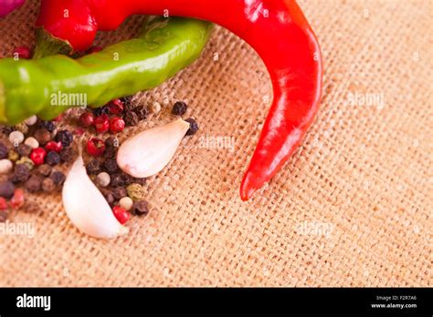 Red Hot Chili Peppers With Spice Ingredients Over Burlap Background