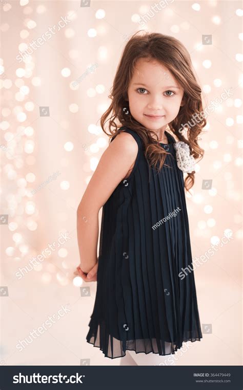 Cute Baby Girl 5 6 Year Old Wearing Stylish Dress Over Lights In Room