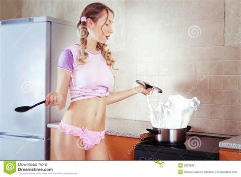 Housewife Cooking Milk Splash In A Pot At The Kitchen