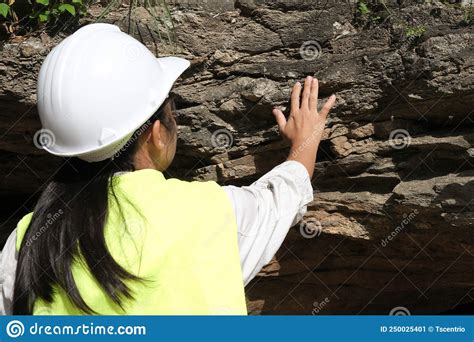 Asian Female Geologist Researcher Touches Rocks With Her Hands To