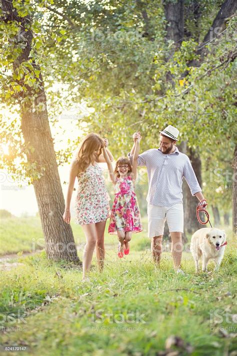 Happy Young Family On A Summer Day With Their Dog Stock Photo ...